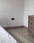 White wall and small bed in bedroom before renovation.