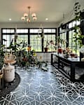 Black and white tiles in plant filled living room before renovation.