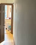 White painted walls in hallway before painting with floral stencil.