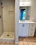 Walk in shower between toilet and vanity in bathroom before renovation.
