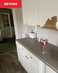 Kitchen countertop with white cabinets, a toaster, mugs, and a water bottle; wall shows damage above the counter.