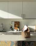Bag on island countertop in white kitchen before renovation.