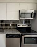 Black tile backsplash in kitchen before updating tiles.
