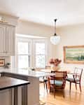 View into dining room from newly renovated kitchen with beige cabinets.