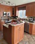 kitchen with beige tile and ambered wood cabinets before makeover