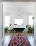 A massive bathroom with a long rug leading to the tub.
