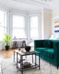 Living room featuring a teal velvet sofa, a coffee table, and a C table