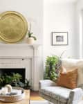 A white brick fireplace with a large gold plate on the mantel