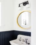 A bathroom with navy blue wainscoting and white upper walls