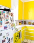 A kitchen with yellow cabinets and drawers