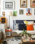 Eclectic living room with patterned sofas, colorful cushions, wall art, plants, and a mix of vintage and modern decor.