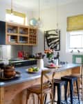 A black and white kitchen with a big wooden island in the middle.