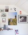Home office with a gallery wall, computer on desk, and a chair draped with a star-patterned blanket.