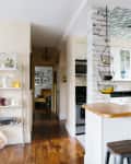 A neutral kitchen with a hanging basket for fruit over the counter