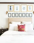 Artwork in matching frames arranged neatly on a bedroom wall