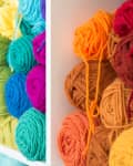 Colorful yarn balls stacked on white shelves, featuring shades of green, blue, orange, and red.