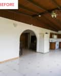 Spacious kitchen with wooden cabinets, white appliances, tiled floor, and exposed beam ceiling.