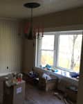 Dining room with patterned wallpaper, red candle chandelier, large window, and unpacked boxes on the floor.