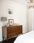 A small bedroom with a narrow storage cabinet in the corner