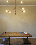 Dining room with wooden table, modern chandelier, step ladder, and tools on table, marked "Before" in red banner.