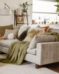 Gray sofa in living room with textured pillows and blankets