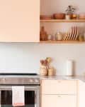 A peach kitchen with open shelving