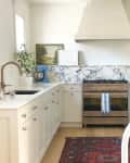 Kitchen with marble backsplash, lamp, and red vintage rug