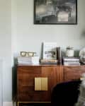 Living room credenza with books, disco ball, and vase of flowers on top