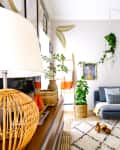 Bright living room with blue-gray sectional, Beni Ourain-like rug, and lots of plants