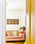 white hallway with kitcat clock and view into living room