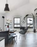 white minimalist living room features black accents like furniture, chairs and light fixtures