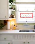 A stain glass window above white counter tops.