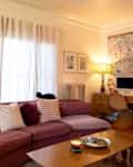 A plum colored camino-sectional-sofa in a living room.