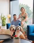 A man and woman in their living room with two dogs