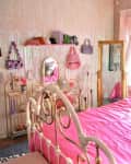Colorful bedroom with lots of pink and lavender accents. One wall with opalescent beads. Lots of colorful art, decor