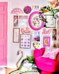 colorful living room with some pink walls, some white, pink front door, blue velvet sofa with colorful throw pillows, arched deco mirrors, lots of colorful framed wall art