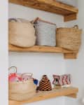 Philadelphia residence with white walls, lots of wood details: wood shelf storage in bathroom with multiple baskets