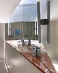 Bathroom with large glass shower, rust colored marble countertops