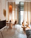 White brick living room with off white sofa, stone floor, large windows, and lots of neutral and warm tones