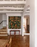 Tapestry hung above decorative chairs in Barcelona apartment.
