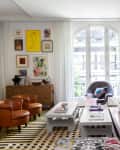Buenos Aires, Argentina house tour living room. Large light gray sofa, patterned rug, textiles, white walls, large windows
