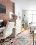 Studio apartment in New York City with space for bedroom, small living area and work desk.