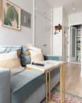 Studio apartment with microfiber sofa and small kitchen space.