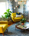 Living room with cognac colored leather sofa and two yellow chairs.