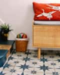 Blue living room with star motif tiles and wooden shoe storage.