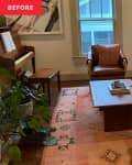 Living room with a white sofa, leather chair, piano, and a car seat on a patterned rug.