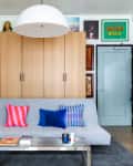 entryway seating area with gray sofa, gray rug, metal coffee table, blue/gray door, tall locker-style cabinets, gallery wall