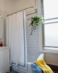 Blue and white striped shower curtain in white tiled bathroom.