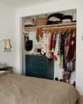 Black painted dresser in neatly organized bedroom closet.