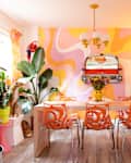 Orange vintage dining chairs in colorful dining room.